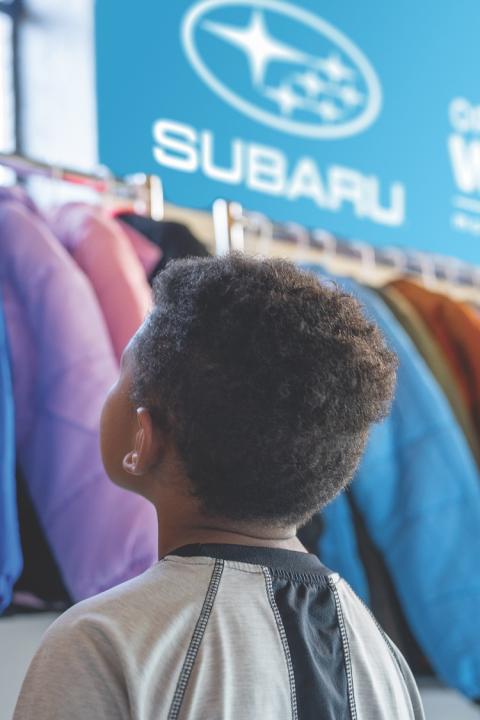 Subaru Coat Drive with Operation Warm - boy looks at coats